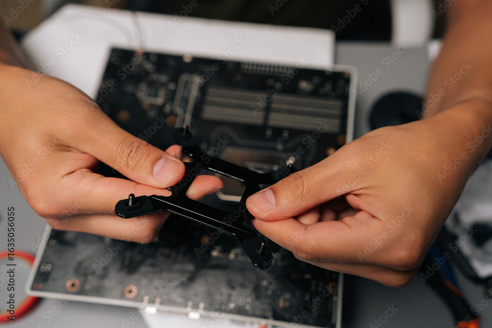 Poster top view of computer technician mounting cpu cooler bracket on motherboard, ensuring precise hardwar