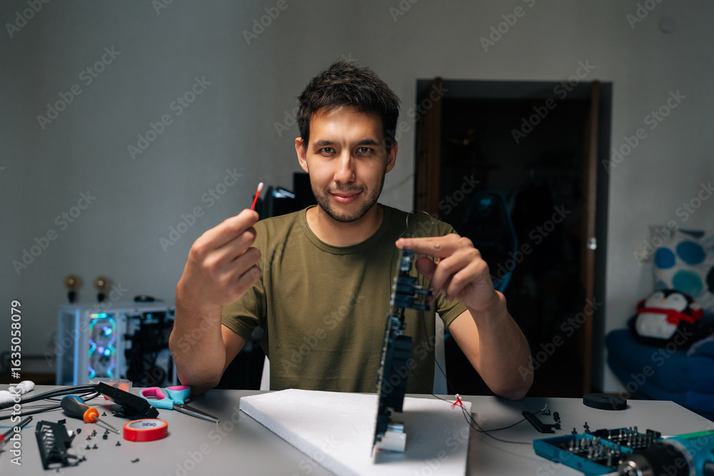 Poster portrait of computer service technician repairing computer part while holding cotton swab and lookin