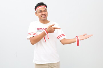 Happy Indonesian man with red and white ribbon celebrating Indonesian independence day while...