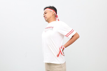 Indonesian man with red and white ribbon celebrating Indonesian independence day while having back...