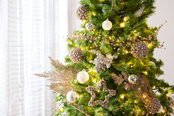 Luxurious close-up of elegant Christmas tree decorated with champagne gold ornaments, glitter...