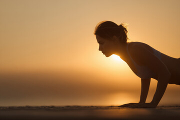 young woman performs plank exercise on beach her face expressing determination and strength