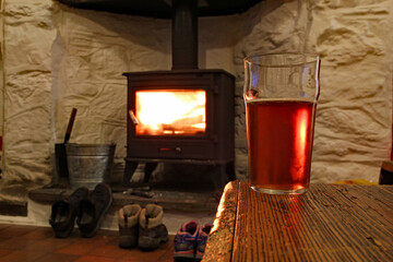 Well earned beer in front of a roaring pub fire that’s drying boots after a long country hike
