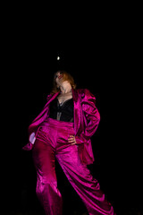 Waacking dancer in vibrant fuchsia attire under the night sky