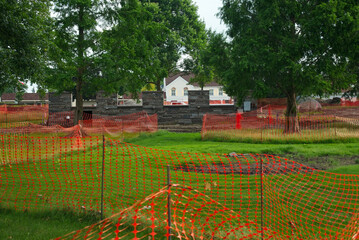 Temporary mesh fencing criss-crosses the lawn of the town square in Twinsburg Ohio in preparation for renovation and reconstruction work over the course of the summer.