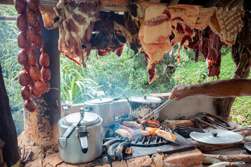 Traditional Colombian BBQ with Man Grilling Meat in Rustic Outdoor Kitchen
