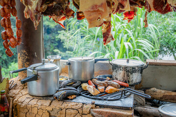Hanging Smoked Meats and Chorizo Above Traditional Colombian Grill