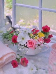  窓辺に薔薇とペチュニアのアレンジメント