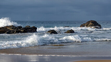 Waves breaking around rocks just off the beach in Zipolite, Mexico