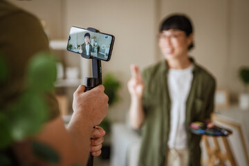 Man recording a painter creating online content with a gimbals © Miljan Živković