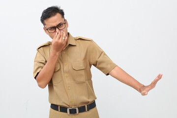 Indonesian civil servant covering nose and denied something from side. Bad smell concept
