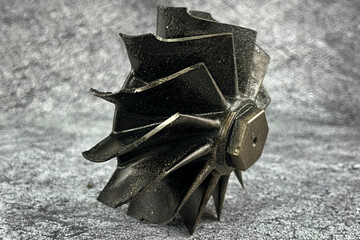 Damaged turbocharger compressor wheels and broken shaft  with black blades from carbon residue from...