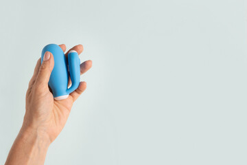 Vaginal kegel smart trainer with biofeedback in woman hand on blue background. Smart trainer for...
