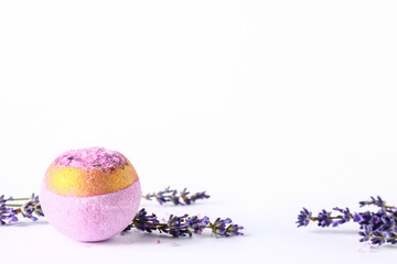 Bath bomb and aromatic lavender flowers on light background
