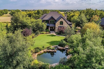 Obraz premium Charming country house with lush garden and pond for sale amidst serene landscape, perfect for nature lovers