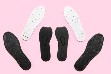 Composition with different orthopedic insoles on pink background