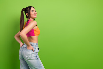 Bright young woman posing confidently against colorful green background wearing trendy summer...
