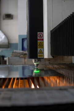 Vertical de m&aacute;quina cortadora y caladora de metal con puntera l&aacute;ser control y manos operario trabajador