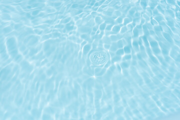 Blue water with ripples on the surface. Defocus blurred transparent blue colored clear calm water surface texture with splashes and bubbles. Water waves with shining pattern texture background.