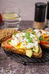 Grid of tasty sandwiches with egg on table
