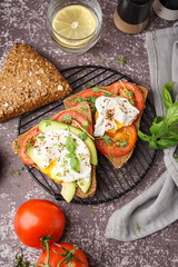 Grid of tasty sandwiches with egg on grey background