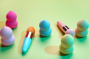 Different makeup sponges on green background