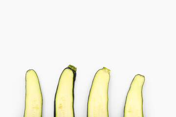 Slices of fresh green zucchini on white background