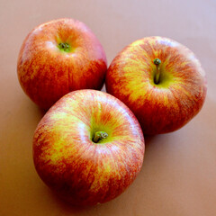 A closeup of three Royal Gala apples. 