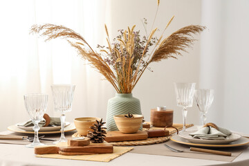 Elegant table setting with dried flowers, pampas grass and pine cones