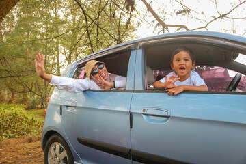 happy little boy with family sitting in the car
