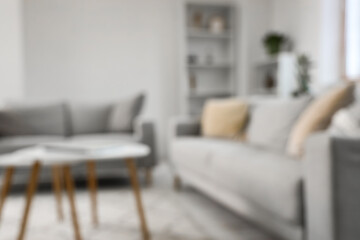 Stylish interior of living room with sofa and coffee table, blurred view