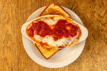 portion of lasagna with garlic bread