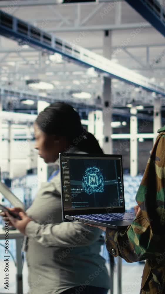 Poster vertical video army programmer in high tech server hub uses ai application on laptop to review recon