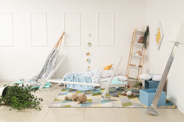 Broken bed with toys on carpet in messy children's room