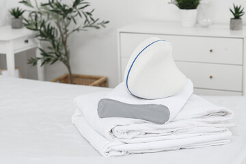 Soft orthopedic pillows and bedding on bed in room