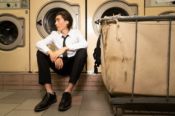 Young business man hangs out at Laundromat 