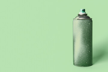 Spray paint can on green background