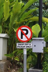 A clear 'No Parking' sign combined with a 'Drop Off & Pickup Only' instruction, prominently...