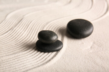 Black stones on light sand with lines. Zen concept
