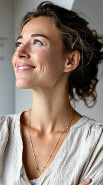 Woman gazing upward indoors with contentment and thoughtfulness