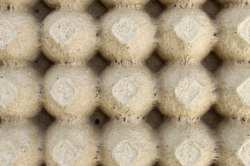 Empty egg carton texture made from textured recycled material, neutral gray in color. This natural background is suitable for eco-friendly designs, recycled themes, or organic product presentations.