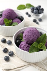 Tasty sorbet with blueberries and mint in bowls on white table, closeup