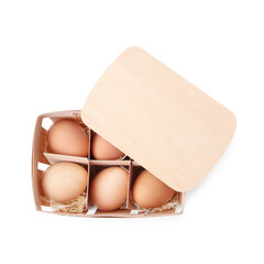 Raw chicken eggs in wooden egg tray isolated on white, top view