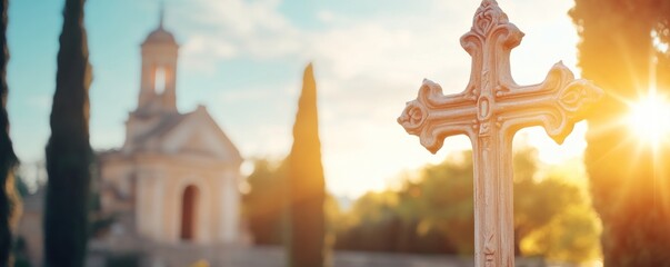 Stone cross monument with church and sunlight scenic landscape