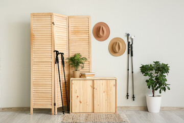 Interior of room with Nordic walking poles, folding screen and hats