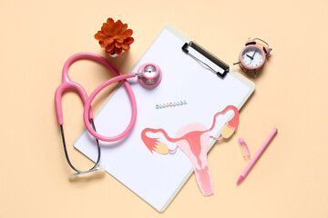 Clipboard with word MENOPAUSE, alarm clock, stethoscope and paper uterus on beige background