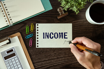 There is a piece of paper with the word Income. It is as an eye-catching image.