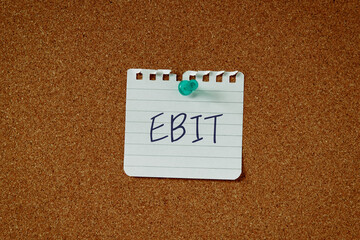 There is a piece of paper with the word EBIT. It is an abbreviation for Earnings Before Interest...