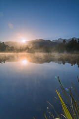 ニュージーランド　早朝の霧がかったレイク・マセソンから見えるマウント・クックと昇る太陽