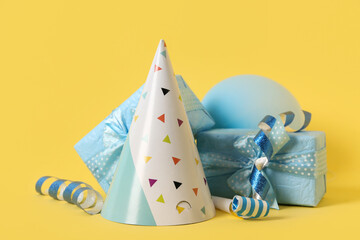 Composition with beautiful gift boxes, party hat and balloon on color background